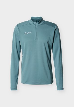 Jasnoniebieska sportowa bluza z długim rękawem, zapinana na ćwierć zamek, z białym logo Nike Swoosh na lewej piersi.