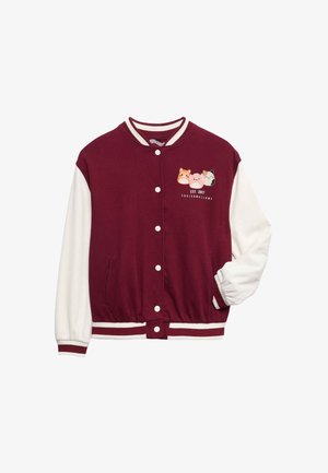 Burgunderfarbene Collegejacke mit weißen Ärmeln, weißem T-Shirt, passenden burgunderfarbenen Jogginghosen mit seitlichen Streifen und Grafiken sowie beigen Sneakers.