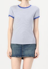 T-shirt à manches courtes bleu et blanc rayé avec un col et des manches côtelés bleus en contraste, associé à une mini-jupe en denim.