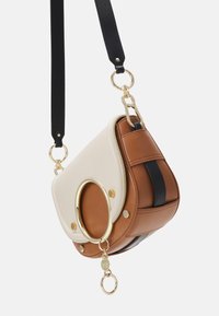 Borsa in pelle con pattina beige e corpo marrone, impreziosita da dettagli in oro e un accento circolare, con una tracolla nera.