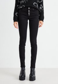 Fekete, skinny farmernadrág, magas derékkal, öt gombos záródással és klasszikus hátsó zsebekkel. Rugalmas denim anyagból készült.