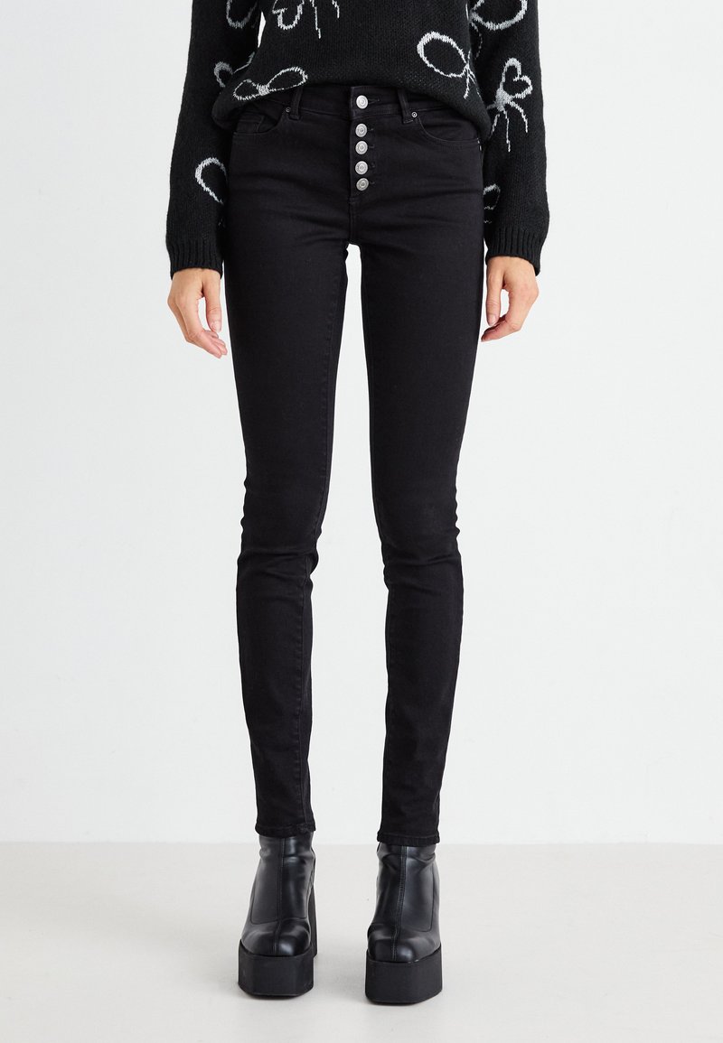 Fekete, skinny farmernadrág, magas derékkal, öt gombos záródással és klasszikus hátsó zsebekkel. Rugalmas denim anyagból készült.