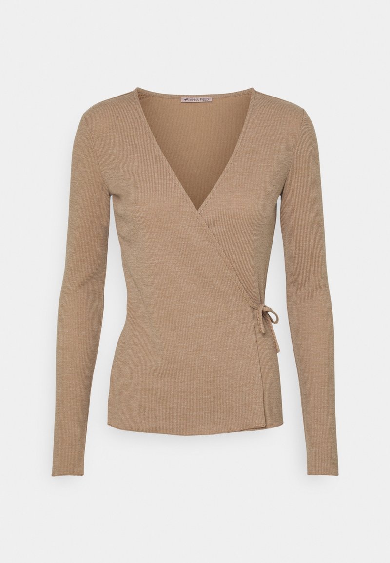 Beige langärmlige Wickeljacke mit V-Ausschnitt und seitlichem Bindebandverschluss, geripptes Strickmuster, taillierte Silhouette.