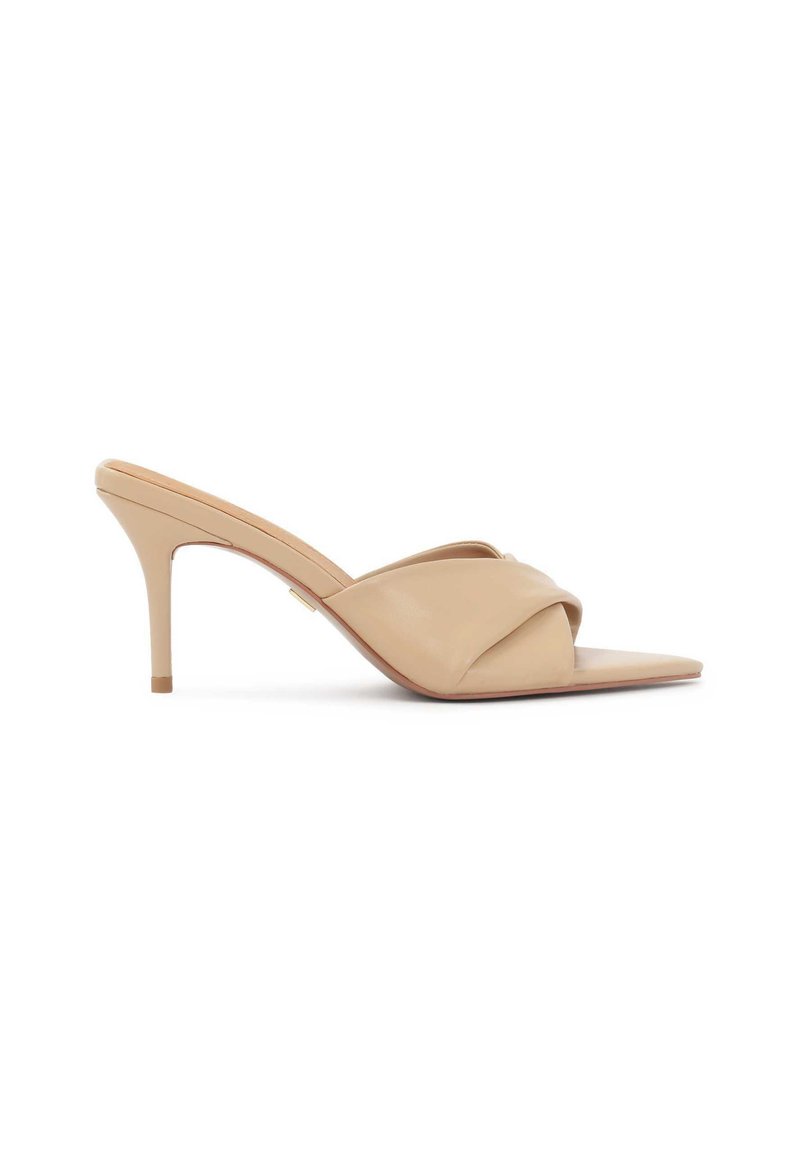 Beige hoge hak mules met een puntige neus, gemaakt van glad leer en een gekruist bandontwerp. Slanke stilettohak verhoogt de elegantie.