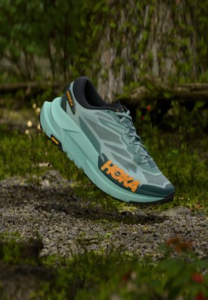 Letløbesko i lys grønblå med orange accenter. Har en åndbar mesh-overdel, tyk polstret sål og robust ydersål for godt greb.