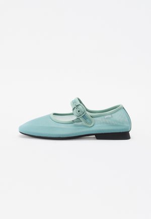 Chaussures Mary Jane de couleur teal clair avec un bout arrondi, une tige en mesh et une boucle ajustable. Semelle noire plate et design minimaliste.