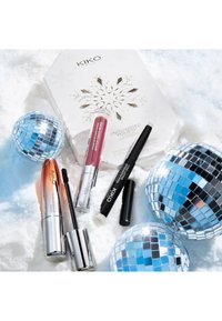 Set de regalo KIKO sobre nieve: caja metálica con diseño de copos de nieve, dos lápices labiales brillantes, máscara de pestañas y lápiz iluminador. Tres bolas de discoteca reflectantes.