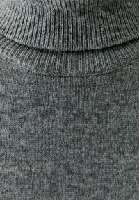 Gray turtleneck sweater made of knitted fabric. Features ribbed collar and texture with subtle variations in shade and pattern.