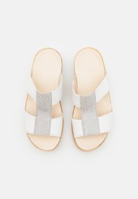 White slide sandals with a textured silver band across the center, cork sole, and a comfortable padded insole. Smooth finish throughout.