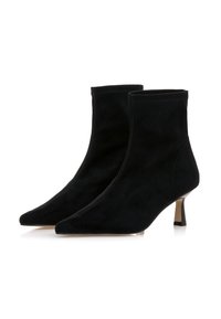 Bottes noires en suède à talons mi-hauts et bout pointu. Texture lisse avec un design sans couture et sans matériel visible.