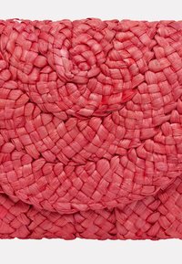 Vävd väska i klar rosa, tillverkad av naturliga fibrer. Har intrikata flätningar och en strukturerad yta med en smidig finish.