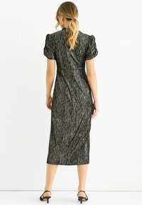 Black midi dress with a textured metallic finish, puff sleeves, and a fitted waistline, featuring a straight cut and subtle vertical stripes.