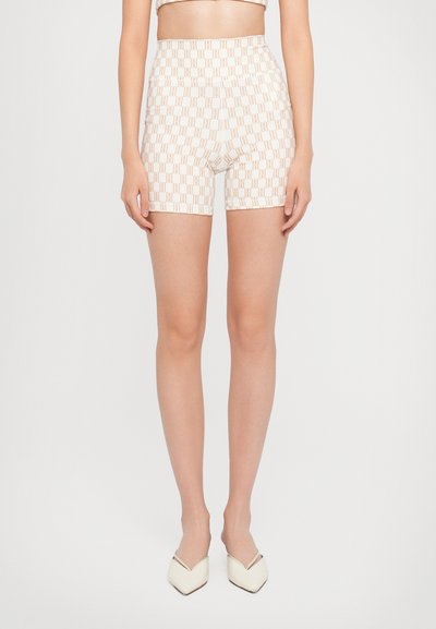 Shorts taille haute en tissu crème avec un motif géométrique répétitif en brun clair. Présente une texture lisse et une coupe ajustée.