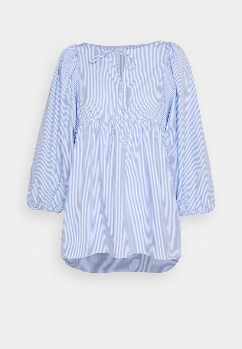 Blouse manches longues à rayures verticales bleu clair et blanc, taille froncée, poignets élastiques, encolure dégagée et nœud noué à l'avant.