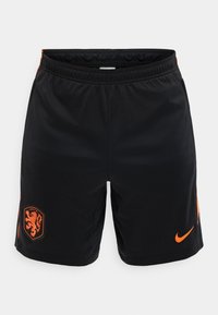 Μαύρο σπορ σορτς με πορτοκαλί λογότυπο Nike στο δεξί πόδι και πορτοκαλί έμβλημα λέοντα στο αριστερό πόδι, με ελαστική μέση.