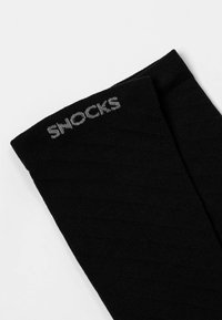 Black socks with a ribbed texture, featuring the word "SNOKS" woven in gray near the top cuff.