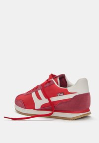 Baskets de sport rouges avec une tige en tissu lisse, des accents en suède, des bandes blanches et une semelle en caoutchouc. Les lacets sont rouges et de design plat.