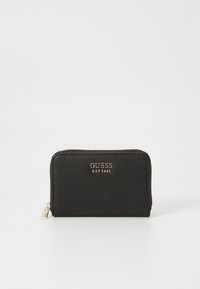 Portafoglio in pelle morbidamente martellata nera, con chiusura a zip, logo dorato "GUESS EST 1981" e una piccola cerniera. Forma rettangolare.