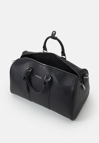 Black leather duffle bag with dual handles, silver hardware, and a zip closure. Features a branded detail and an open interior.