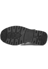 Zwarte rubberen zool met een gestructureerd profiel, voorzien van een zigzagpatroon en een hexagonaal ontwerp voor verbeterde grip en stabiliteit.