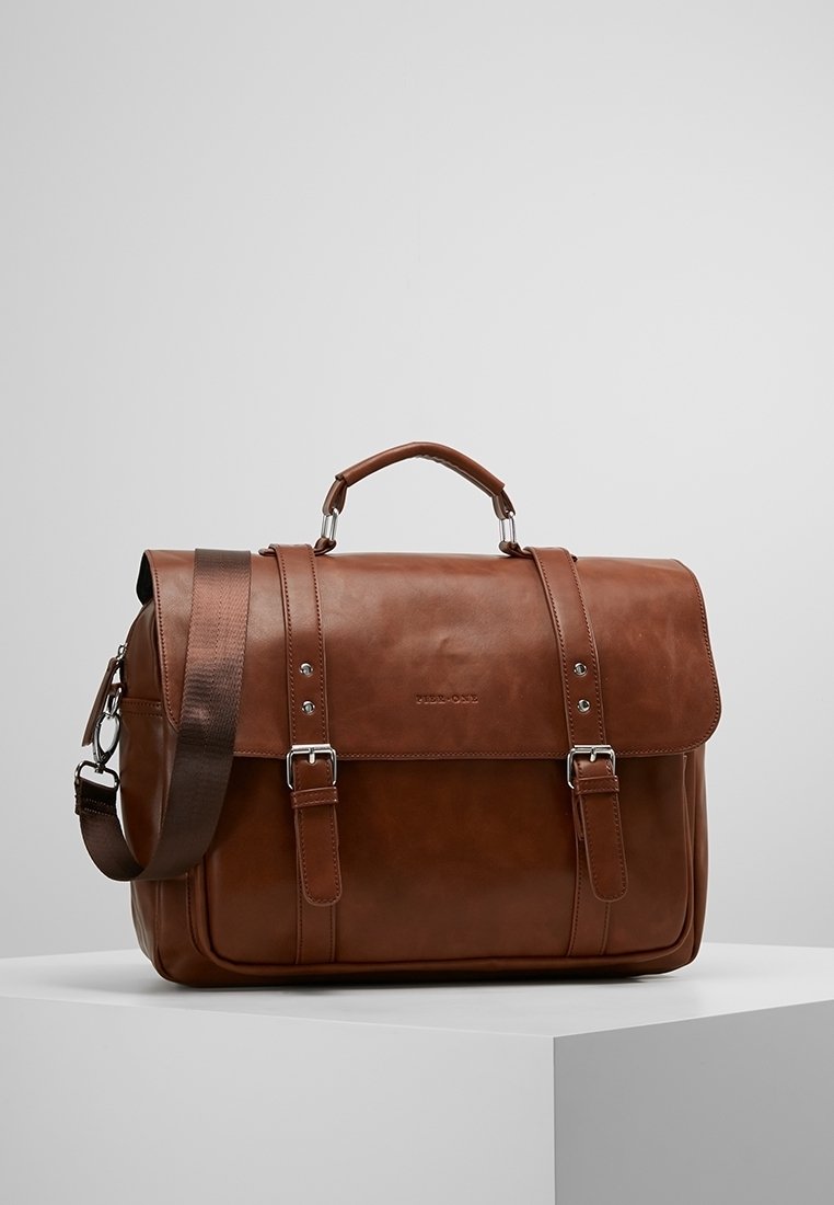 Sac messager en cuir marron avec une fermeture à rabat, doté de deux boucles à l'avant, d'une poignée supérieure et d'une bandoulière ajustable. Texture lisse.