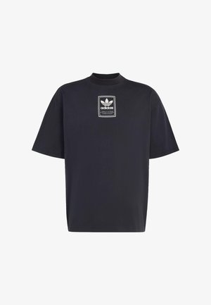 Zwarte oversized korte mouwen T-shirt met ronde hals en een witte Adidas Trefoil-logo patch in het midden op de borst.