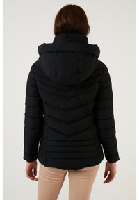 Black puffer jacket with a hood, featuring a chevron design and quilted texture. The sleeves are fitted, and the back has a smooth finish.