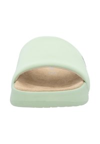 Sandale à glissière vert clair avec une tige synthétique lisse et une semelle intérieure douce et texturée couleur tan. Présente une silhouette arrondie et une semelle flexible.