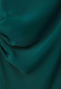 Tela en color teal con una textura suave y mate, que presenta pliegues sutiles y reflejos de luz, creando suaves pliegues y curvas.