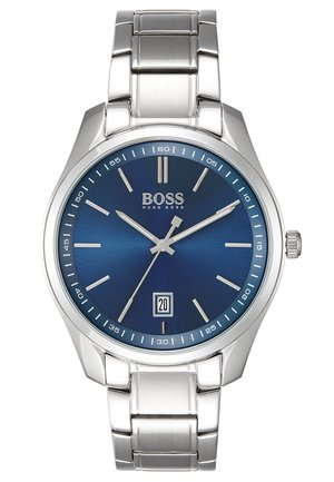Silver metal wristwatch with blue dial, slim silver hour markers, date window at 6 o’clock, and brand name "BOSS Hugo Boss" below 12 o’clock.