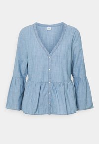 Blouse bleu clair en mélange de coton avec col en V, fermeture à boutons et taille peplum. Comprend des manches longues en forme de cloche et une texture douce.