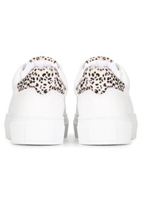 Zapatillas blancas con parte superior de cuero texturizado, con un acento de estampado de leopardo en el talón. Suela plana de goma con un diseño minimalista.