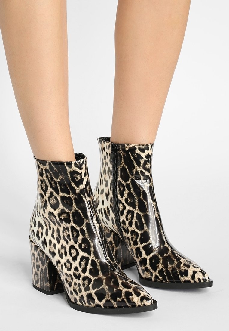 Stivali alla caviglia con stampa leopardata, finitura lucida, punta affusolata e tacco a blocco. Presentano una zip laterale per una facile vestibilità.