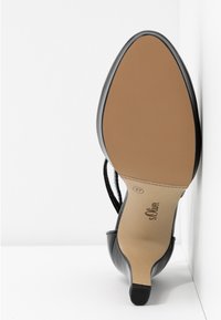 Chaussure à talon haut noire vue de la semelle, montrant une semelle beige texturée, taille 37, et la marque "s.Oliver" sur fond blanc.