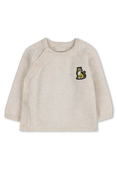 Kremowy sweterek dziecięcy z guzikami po bokach i małym haftowanym na piersi żółto-czarnym tygryskiem.