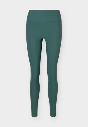 Leggings de color azul verdoso con textura acanalada de talle alto, ajuste ceñido, diseño sin costuras y sin logotipos ni patrones visibles.