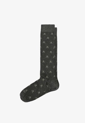 Calcetines hasta la rodilla de color gris oscuro con un patrón de calaveras y huesos cruzados en gris claro por todo el tejido.