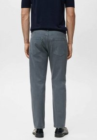 Grå denim jeans med lige skæring, der har to baglommer og en subtil vaskeeffekt. Bæres med en kortærmet marineblå top.