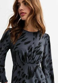 Langärmliges Kleid aus dunkelgrauem Satin mit schwarzen abstrakten Mustern, ausgestattet mit einer taillierten Taille und sanften Puffärmeln.