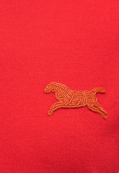 Κόκκινο ύφασμα με ένα μικρό κεντημένο άλογο από πορτοκαλί χάντρες σε στάση τρεξίματος στην κάτω δεξιά πλευρά.