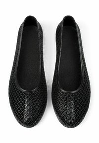 Chaussures plates noires avec un motif en losanges texturé, bout rond et intérieur rembourré. Fabriquées en matériau flexible pour le confort et une utilisation facile.