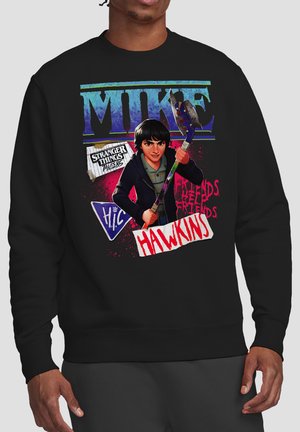 Character Mike from Stranger Things holding an axe, with text "Mike," "Hawkins," "Friends Help Friends," and "Stranger Things Tales 85" on black sweatshirt.