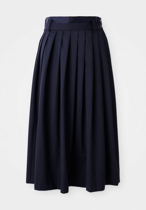 Jupe midi plissée bleu marine avec une taille haute, des passants de ceinture, un détail de ceinture latéral et de subtils rayures verticales sur un fond blanc.