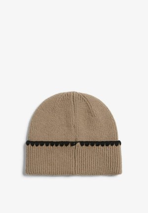 Beige strikket hat med ribbet tekstur, pyntet med en sort bølget accentbånd. Enkel, rundet design for varme og komfort.