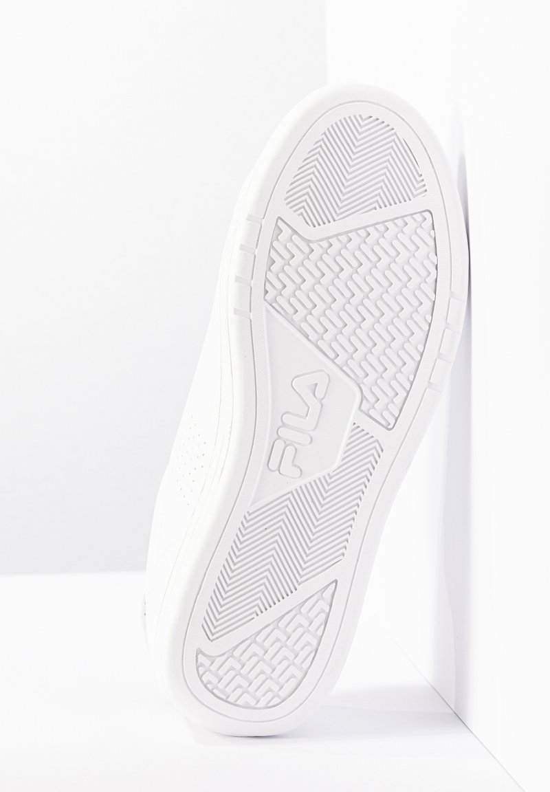 Biała gumowa podeszwa sneakersów z teksturowanym wzorem gripu i wytłoczonym logo. Zawiera zaokrągloną krawędź i otwory wentylacyjne po bokach.