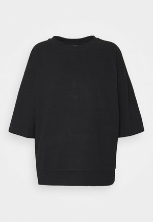 Zwart oversized sweatshirt met korte mouwen, ronde halslijn en rechte zoom op een effen witte achtergrond.
