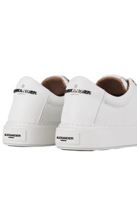 Sneakers bianchi in pelle con suola spessa. Caratteristiche includono il logo in rilievo "Alexander London" sul tallone e una texture liscia.