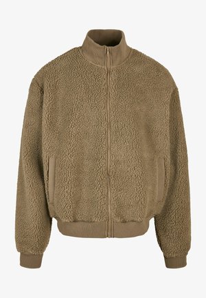 Kollane lukuga jakk, mis on valmistatud tekstuursest fliisist, kõrge kaelusega, elastsete mansettide ja küljetaskutega. Pehme ja soe välimus.