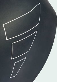 Matná čierna produkt s abstraktnými bielymi geometrickými tvarmi. Hladký povrch, minimalistický dizajn, obsahujúci asymetrické vzory a čisté línie.