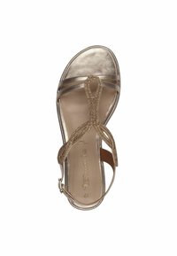 Sandale métallique dorée avec un design de T-strap perlé, bout ouvert et bride de cheville. Texture en cuir lisse, semelle rembourrée et forme courbée.